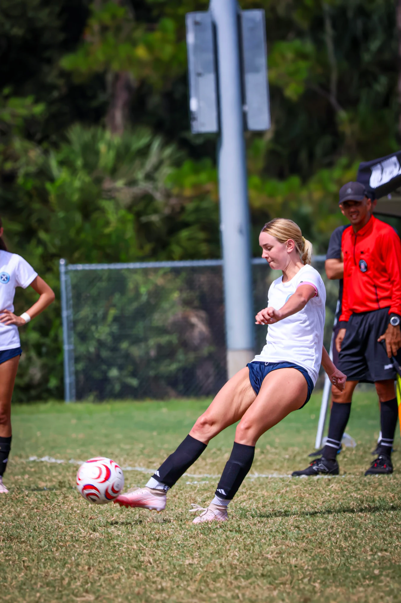 Player striking the ball in a white kit